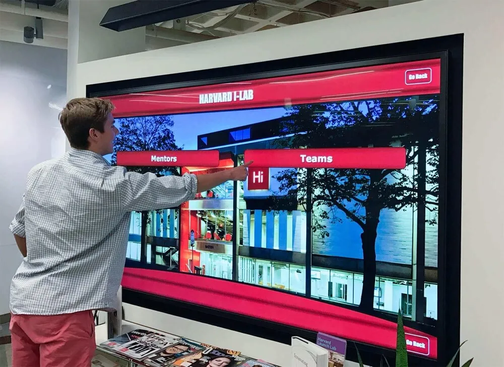 Student using touchscreen to explore academic recognition wall