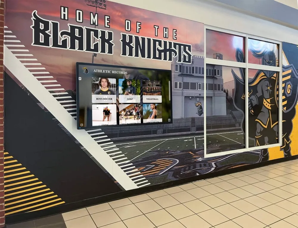 School hallway featuring athletic records display and program branding Athletic facility digital display