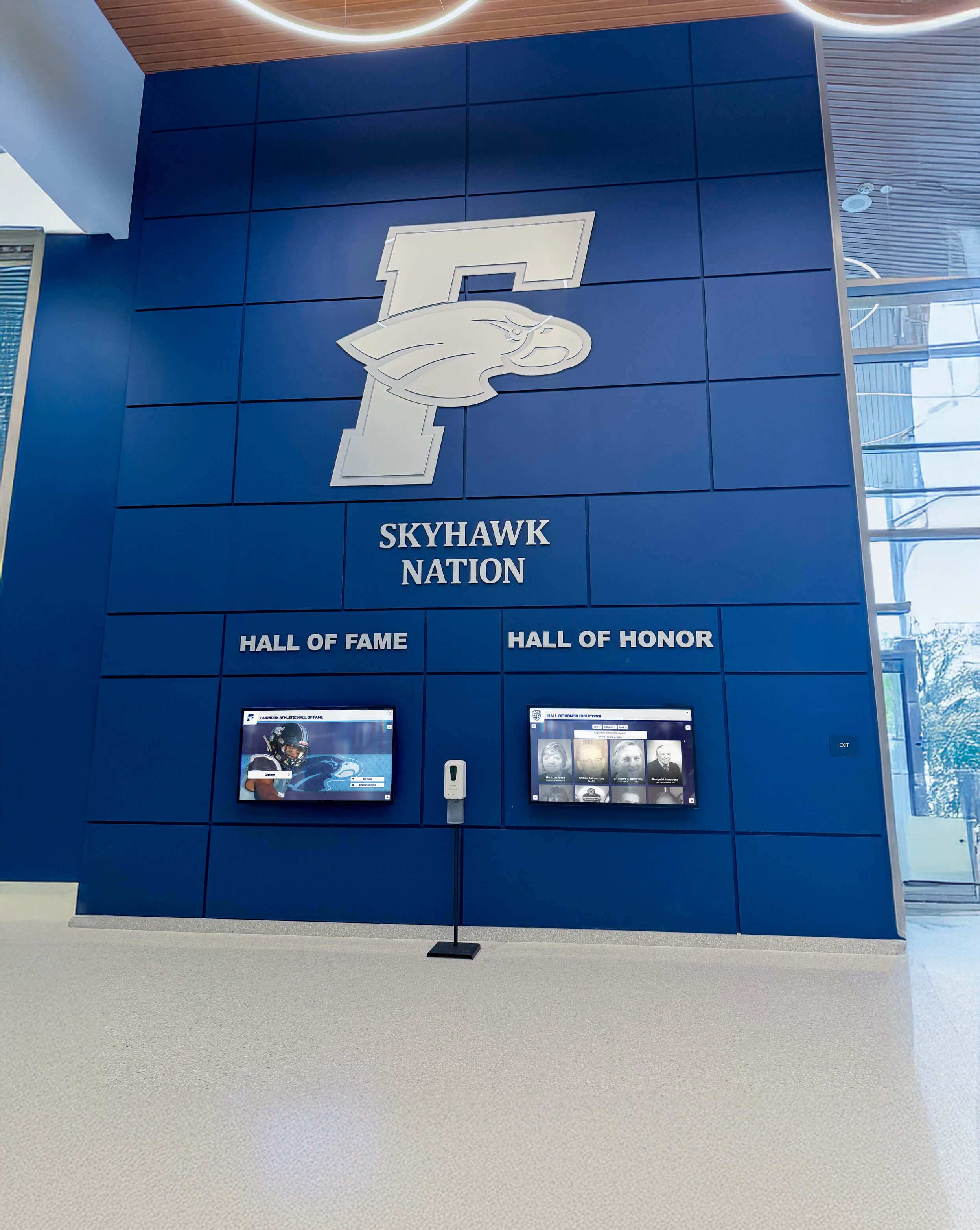 School lobby honor wall with digital recognition display in blue color scheme